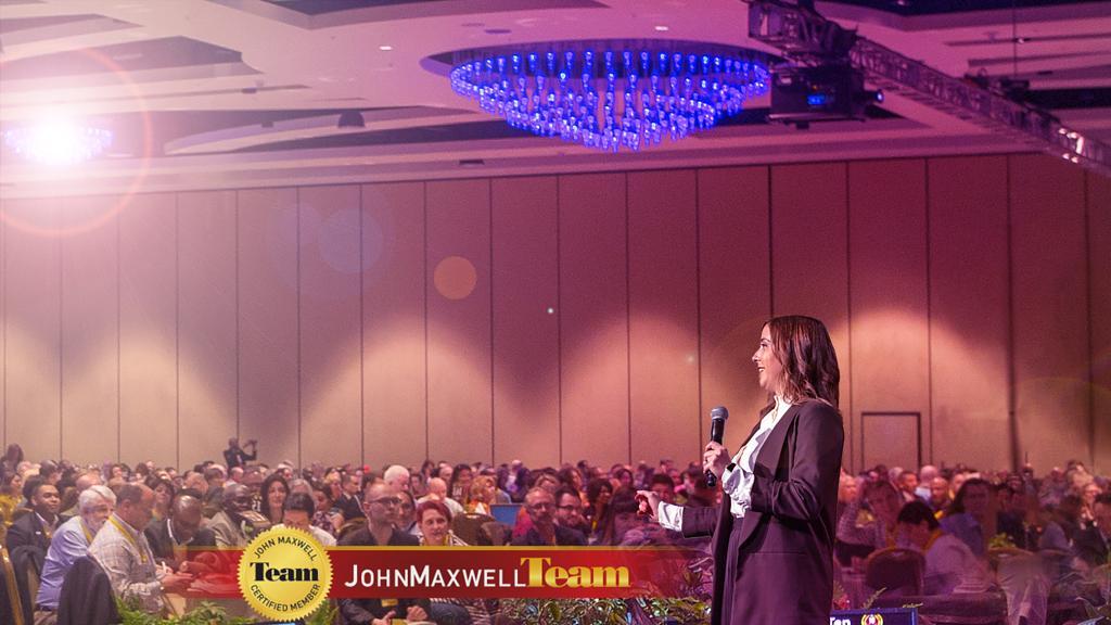 Carolina Marin speaking to a large audience at a Maxwell Leadership conference